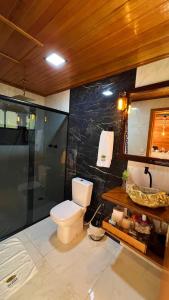 a bathroom with a toilet and a shower and a sink at Chalés Vista dei Monti in Dois Lajeados