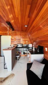 a kitchen with a wooden ceiling and a counter at Chalés Vista dei Monti in Dois Lajeados