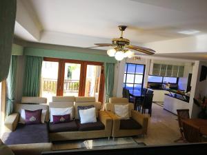 a living room with a couch and a ceiling fan at Private Pattaya Resort in Nong Prue