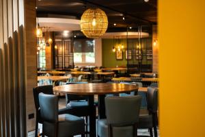 a dining room with tables and chairs and lights at Kents Hill Park Training & Conference Centre in Milton Keynes