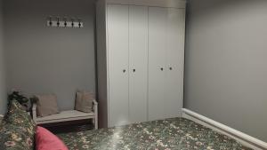 a bedroom with white cabinets and a bed and a chair at Timón, cerca de la Playa in Candás