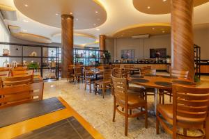 a restaurant with wooden tables and chairs at Nohotel Premium Americana in Americana