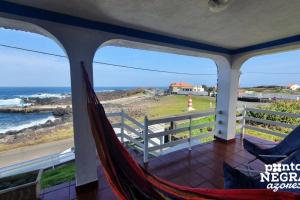 a hammock on a balcony with a view of the ocean at Casa da Maresia by PontaNegraAzores in Biscoitos