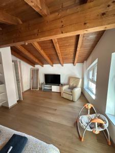 a large living room with wooden ceilings and a couch at Nave San Rocco, Trentino in Nave San Rocco