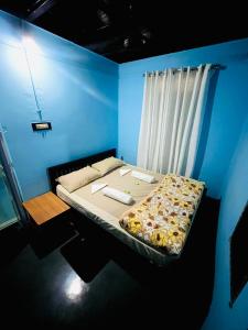 a bed in a room with a blue wall at Arapura Veedu Heritage Homestay in Kizhillam +26 photos