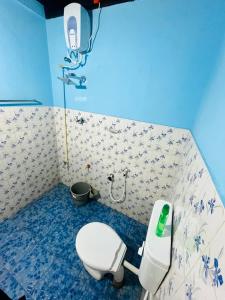 a bathroom with a white toilet in a blue room at Arapura Veedu Heritage Homestay in Kizhillam