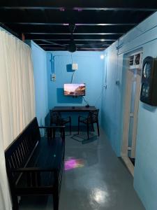 a room with a bench and a table with a tv at Arapura Veedu Heritage Homestay in Kizhillam