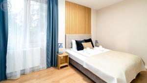 a bedroom with a large bed and a window at Apartamenty Good Time- Mariental Residence - Centrum in Szklarska Poręba
