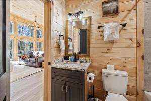 a bathroom with a toilet and a sink at Bearodise By Beyond Expectations W Hot Tub in Glade +62 photos