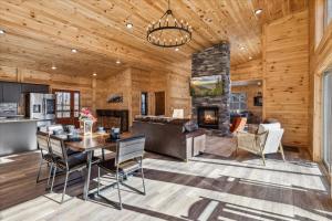 a kitchen and living room with a table and a fireplace at Bearodise By Beyond Expectations W Hot Tub in Glade