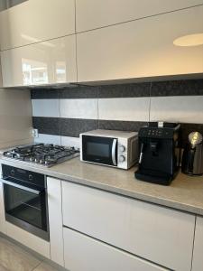 a kitchen with a microwave and a coffee maker at Alex MNL lux Apartment 2 free parking in Bucharest
