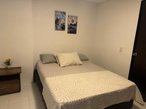 una piccola camera da letto con un letto e una cassettiera di Gran loft cerca al tesoro y al lleras 121 a Medellín