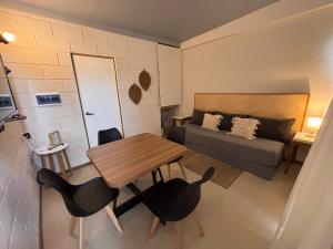 a small living room with a table and a bed at Apart Las Tunas Carmelo in Carmelo