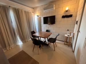 Un comedor con mesa y sillas de madera. en Apart Las Tunas Carmelo, en Carmelo