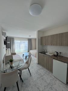 a kitchen and living room with a glass table and chairs at Marianna Hotel Apartments in Limassol