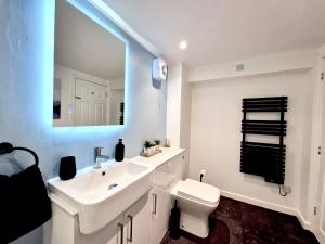 a bathroom with a sink and a toilet and a mirror at Very Spacious, Great location. Castle and Sea view in Marazion +35 photos