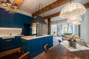 HeřmaniceChâteau du Golf next to Malevil Golf Resort的厨房配有蓝色橱柜和鲜花桌