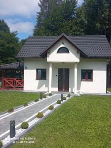 a small white house with a black roof at Gospodarstwo Agroturystyczne in Żabnica