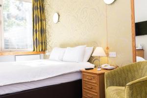 a bedroom with a bed and a chair at Kents Hill Park Training & Conference Centre in Milton Keynes +40 photos