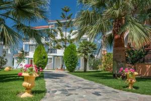 een huis met palmbomen en een loopbrug bij The Dream Hotel in Tragaki