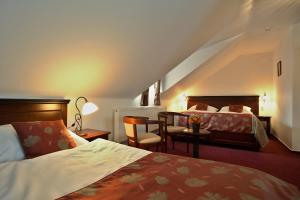 pokój hotelowy z 2 łóżkami i kanapą w obiekcie Hotel Joseph 1699 w mieście Třebíč