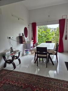 ein Esszimmer mit einem Tisch und Stühlen in einem Raum in der Unterkunft Cloud Nine Kodai, Family Only Boutique Home Stay in Kodaikanal