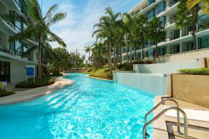 a swimming pool in the middle of a building with palm trees at Wonderful View Duplex in La Vita in Rawai Beach