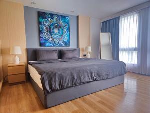 a bedroom with a large bed with a painting on the wall at Wonderful View Duplex in La Vita in Rawai Beach +41 photos