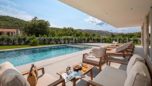a patio with chairs and a swimming pool at Villa ZaLú with Heated Pool in Srinjine
