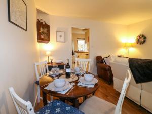 a living room with a table and chairs and a couch at Rose Cottage in Buxton