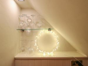 a shelf with wine glasses and lights on it at Rose Cottage in Buxton +33 photos