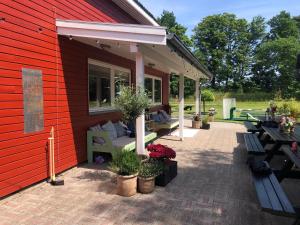 a red house with a patio with benches and flowers at Danhostel Stevns Klint in Store Heddinge