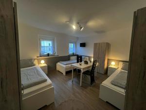 a room with two beds and a table in it at Möblierte Wohnung für 7 Personen - KMK Monteure in Berg