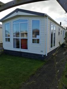 a mobile home with a large window at Chalet 183 auf dem 5 Sterneplatz de Watersnip, Petten in Petten