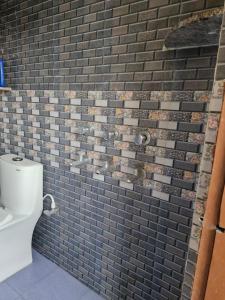baño con pared de ladrillo y aseo en Om Stay Home, en Faizābād 7 fotos más