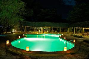 a swimming pool at night with lights around it at Samburu Intrepids Tented Camp in Archers Post