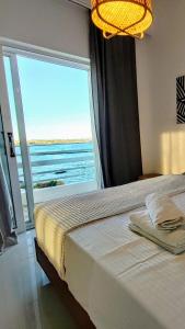une chambre avec un lit et une grande fenêtre dans l'établissement Sirene beachfront central apartment near airport, à Artemi