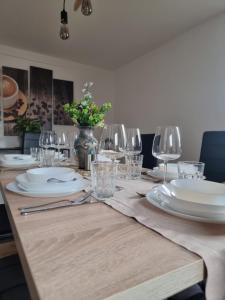a table with plates and wine glasses on it at FeWo Lichtblick in Mengen