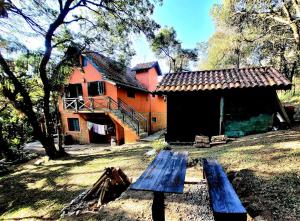 a wooden bench sitting in front of a house at Chalé do Lopo in Extrema