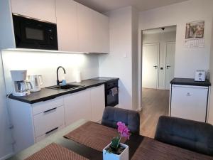 a kitchen with white cabinets and a table and chairs at Räpina Apartment in Räpina