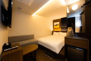 a hotel room with a bed and a couch at Guwol Hotel in Seoul
