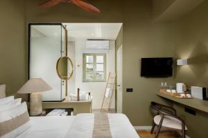 a bedroom with a bed and a mirror at Maison Muse in Hydra