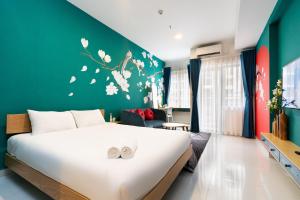 a bedroom with a large bed with white flowers on the wall at Otis Soho Saigon Balcony Apartment in Ho Chi Minh City