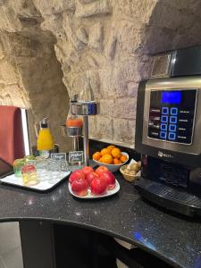 a counter with plates of fruit and a microwave at Hôtel Du Vieux Saule in Paris