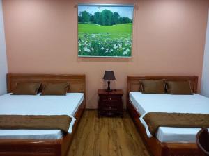 a room with two beds and a painting on the wall at Homestay-Phước Hải in Chợ Phước Hải