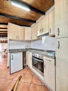 una cucina con mobili in legno e un forno a piano cottura di Casa Dalia a La Orotava Altre 36 foto