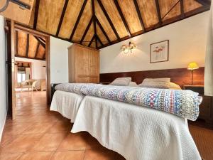 una camera da letto con due letti con lenzuola bianche di Casa Dalia a La Orotava