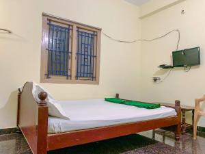 Ahobilam VPS NIVAS Guest House في Pedda Ahobilam: سرير صغير في غرفة بها نافذة