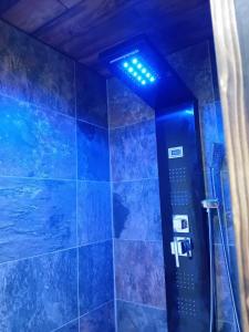 a blue bathroom with a shower with blue tiles at Domaine les lodges nature ,private wellness in Soultzeren +87 photos