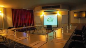 a meeting room with tables and a projection screen at Bakucha Vineyard Hotel ve Spa in Lüleburgaz